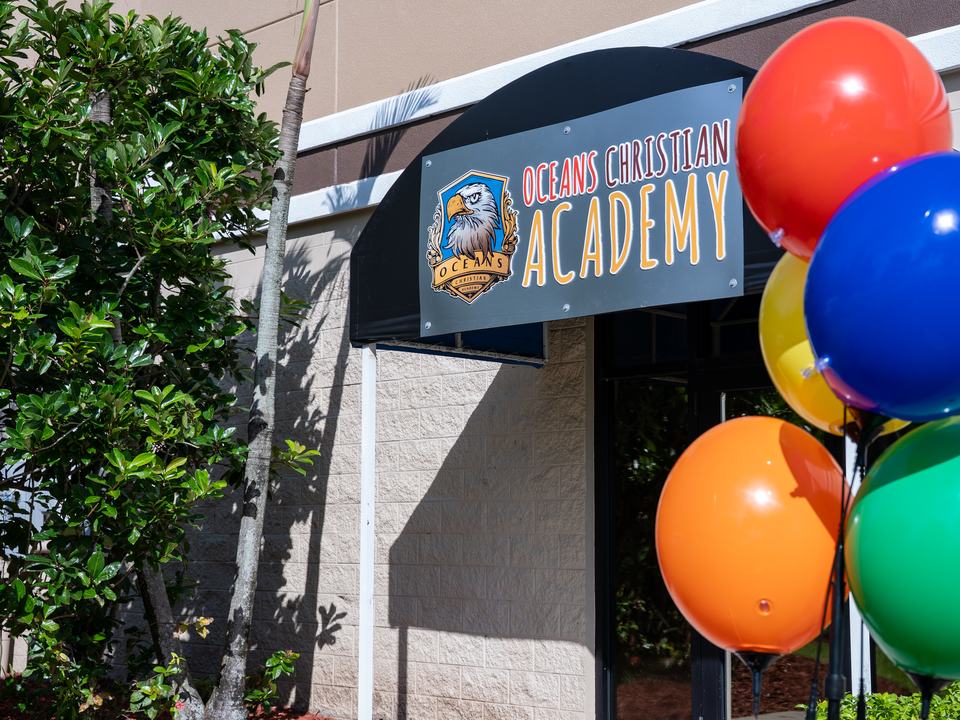 The Oceans Christian Academy sign above the school entrance, with balloons by the door