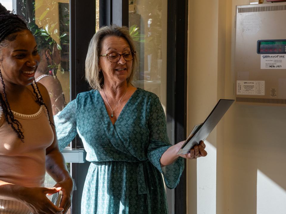 A smiling parent being welcomed at the school&rsquo;s front door