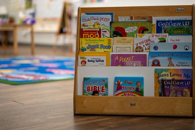 A classroom book display with picture books and a children’s Bible