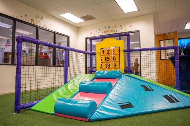 The indoor play area with a soft slide, netting and a number board
