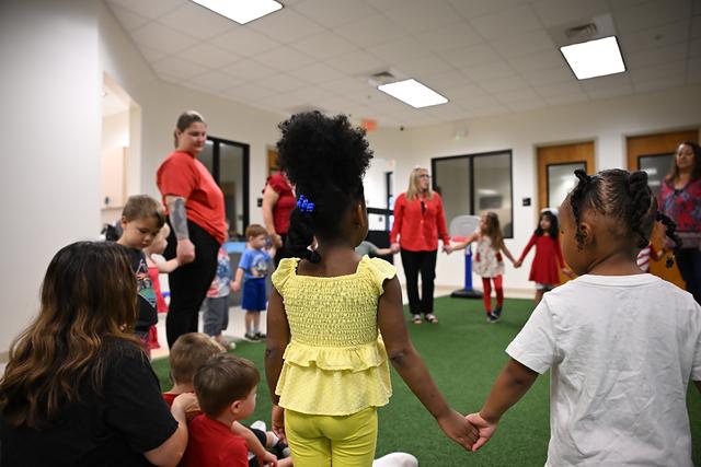 Children and grown-ups holding hands in a big circle
