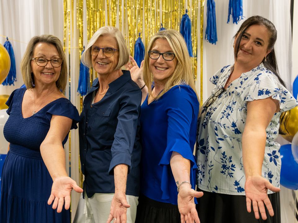 Four staff members smiling at the 2026 graduation